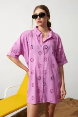 Túnica color lila con bordado de flores, cuello camisero, cierre frontal con botones y mangas cortas.