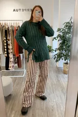 Sweater tejido verde con cuello alto y diseño de trenzas.