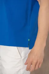 Chomba azul con cuello clásico, tapeta de dos botones y logo bordado en el pecho.