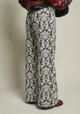 Pantalón de tela jacquard con estampado de arabescos en blanco y negro. Tiro medio/alto, botón y cierre delantero con corte semi wide leg.