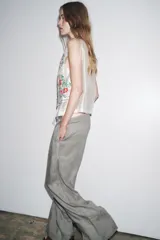 Top blanco de cuello mao y sin mangas, con bordados florales en el frente y cierre con botones.