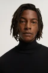 Jersey negro de punto fino con cuello alto y manga larga.