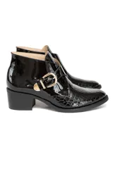 Bota corta de cuero vacuno charolado negro con grabado croco, hebilla dorada y taco medio fachetado efecto madera.