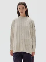 Buzo tejido color blanco, con cuello subido tipo polera, diseño oversized y largo con pequeños cortes laterales.