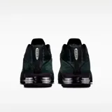 Zapatilla deportiva Nike Shox R4, color negro y verde oscuro (seaweed), con detalles plateados en el sistema de amortiguación Shox. Presenta una capellada de cuero sintético y malla con el logo Swoosh en el lateral.