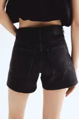 Short de denim negro con cinco bolsillos, cintura estándar con cierre y botón.