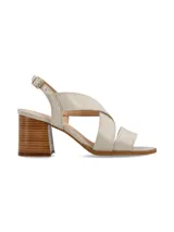 Sandalia de cuero color beige y blanco, con taco de madera y hebilla metálica.