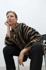 Ruana de punto jacquard con estampado animal print de cebra en colores negro y tostado, de diseño abierto y corte holgado.