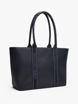 Bolso tote azul marino de poliuretano con cierre de cremallera, doble asa superior con inscripción de Tommy Hilfiger y logo TH dorado en el frente.