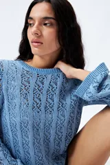 Sweater calado celeste con escote redondo y mangas largas acampanadas, tejido en punto fantasía con dibujo vertical.