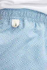 Short de baño celeste con estampado geométrico en blanco, con cintura elástica y cordón ajustable.