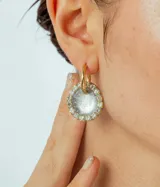 Par de aros colgantes con dije circular de resina con glitter multicolor y borde de strass. El arito es de acero quirúrgico dorado.