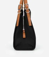 Cartera hobo grande color negro, confeccionada en poliéster y poliuretano. Cuenta con cierre de botón a presión, separadores con cremallera, bolsillo externo, asa mediana ajustable contrastante y detalle triangular de metal.