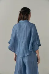 Conjunto de camisa y pantalón celeste con textura arrugada. La camisa es crop con cuello clásico y mangas cortas. El pantalón es de corte ancho con cintura elastizada y cordón ajustable.