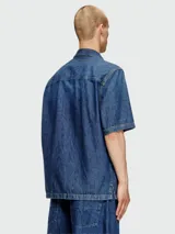 Camisa de jean Diesel modelo D-Paroshort, de manga corta y calce holgado. Tiene dos bolsillos frontales con solapa y cierre con botones.