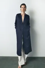 Vestido midi azul marino de viscosa y lino, con cuello redondo, manga larga con puños, abertura en la espalda y cierre frontal con botones.