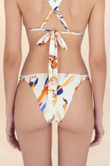 Calzón de bikini de cobertura sutil, color blanco hueso, con estampado abstracto en tonos naranja, azul y rosado. Presenta costuras invisibles y detalles dorados en los laterales.