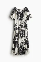 Vestido largo de corte holgado con estampado floral en blanco y negro. Tiene escote cuadrado con cordón ajustable y mangas cortas abullonadas con elástico en los puños. Presenta costura fruncida bajo la cadera.