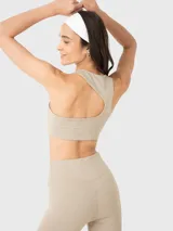 Top deportivo color beige con espalda racerback y almohadillas removibles.
