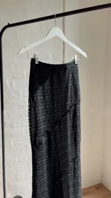 Pollera larga negra de tiro alto con abertura lateral.