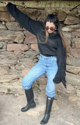 Sweater tejido a mano en lana merino color negro con flecos en las mangas.