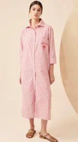 Vestido camisero largo de lino a rayas verticales azules y blancas, con cuello camisero, manga larga y bolsillo en el pecho con bordado. Cierre frontal con botones.