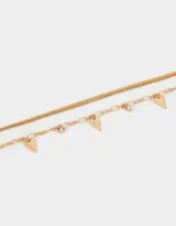 Collar corto de doble cadena dorada con dijes de corazón y strass.