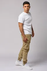 Pantalón cargo color beige de gabardina, con corte ajustado, bolsillos laterales con fuelle y puños elásticos en los tobillos.