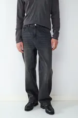 Pantalón de jean negro de corte recto y holgado, con diseño clásico de cinco bolsillos, cierre de botón y cremallera.