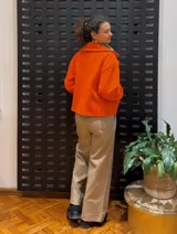 Chaqueta corta de paño color naranja flúor con solapa ancha y forro estampado.