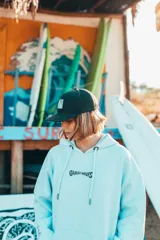 Hoodie color natural con estampado en la espalda con la frase "Glassy Waves" y una tabla de surf con alas.
