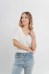 Remera tejida color blanco, con escote en V y mangas cortas.