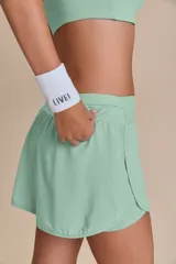 Pollera deportiva color verde lima, con short interno y bolsillo en la cintura.