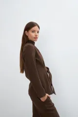 Chaqueta corta color beige, entallada, con escote en V, manga larga y cierre frontal con lazo fijo. Confeccionada en lana fina sin teñir, con bolsillos escondidos y terminaciones enviadas. Hecha 100% en Uruguay.