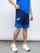 Short de entrenamiento azul marino y azul eléctrico, con escudo del Club Nacional de Football estampado en el lateral.