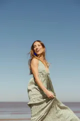 Vestido largo verde con estampado floral blanco, breteles finos y escote en V.