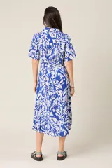 Vestido midi con estampado de hojas en verde y blanco, cuello camisero, botones frontales, manga corta y cinturón.