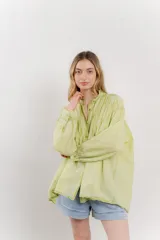 Camisa oversize de algodón color verde lima, con cuello mao con volados y pliegues verticales en el frente.