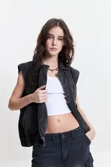 Chaleco denim negro con fit relajado y hombros caídos.