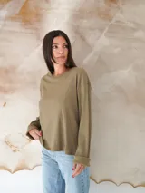 Remera negra de manga larga con cuello redondo. Jeans de tiro alto color celeste con cinturón con hebilla dorada. 