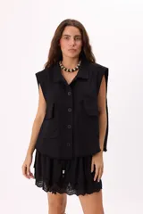 Chaleco color beige estilo cargo con lavado suave, bolsillos frontales y botones negros.