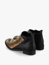 Botín de cuero negro con cierre lateral y detalle de costuras.