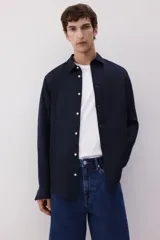Camisa de hombre de lino color azul marino, de corte regular, con cuello inglés, tapeta clásica, mangas largas con puños abotonados y bajo redondeado.