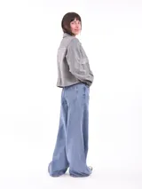 Chaqueta corta gris jaspeado con cuello camisero, cierre frontal con botones a presión, bolsillos de parche con solapa en el pecho y mangas largas.