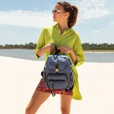 Mochila negra de nylon con tapa y broche metálico. Tiene apertura superior con broche, bolsillos internos, bolsillo con cierre metálico al frente y laterales. Tiene asas rígidas de mano y correas regulables para colgar en la espalda.