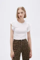 Remera blanca de algodón con cuello redondo, corte al cuerpo y mangas cortas con volados.