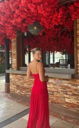 Vestido largo de microtul rojo, con breteles finos y escote en V. Tiene doble tela en la parte superior.