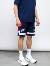 Short deportivo de fútbol azul marino con detalles en blanco y rojo. Presenta el escudo del Club Nacional de Football y el logo de la marca Umbro.