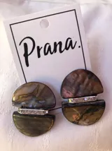 Pendientes con diseño de nácar en tonos beige y detalles brillantes.