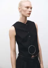 Chaleco negro con cierre de botones en la parte delantera, cuello de pico, sin mangas y dos bolsillos de ribete en la parte delantera.